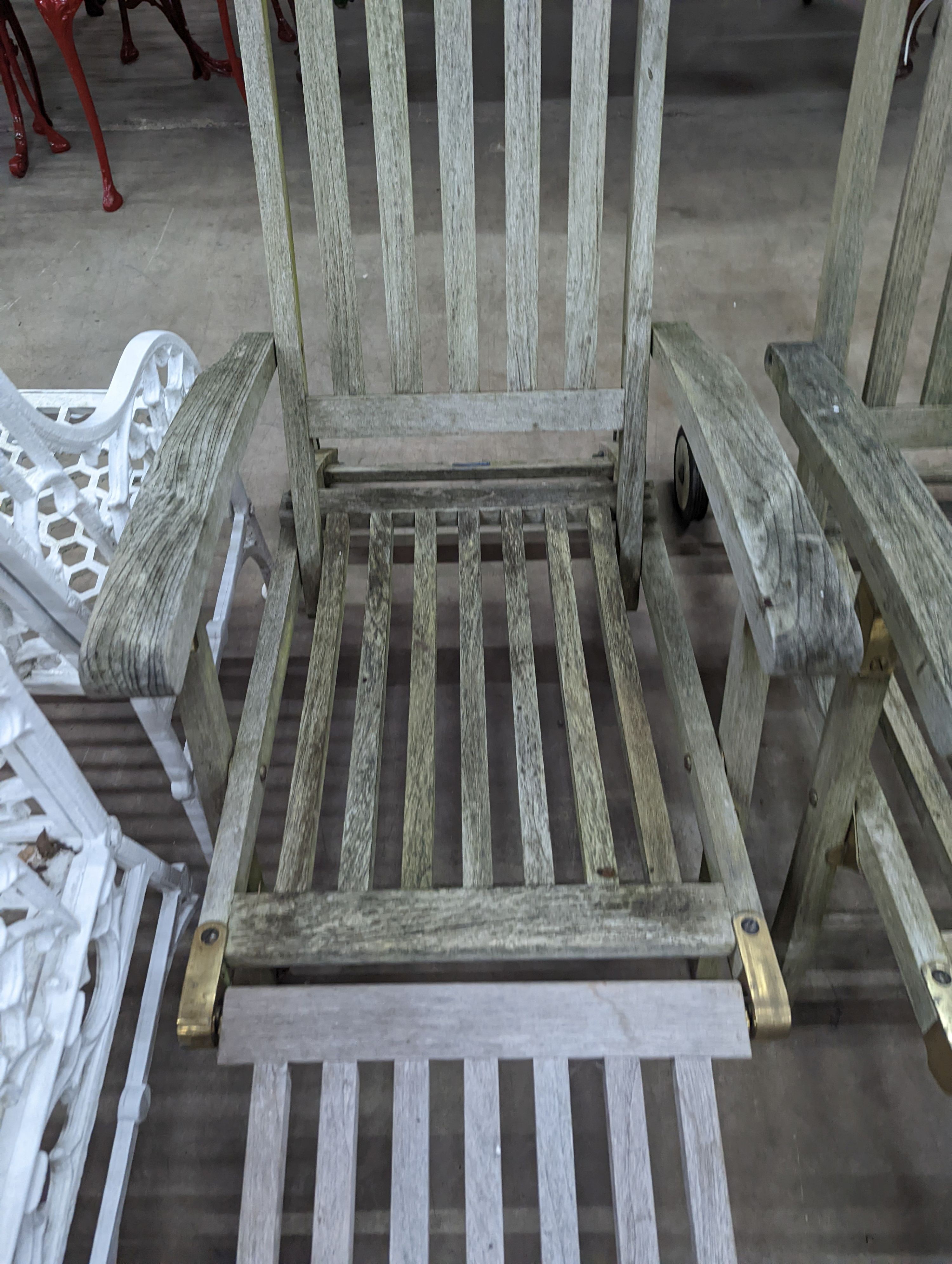 A pair of slatted weathered teak garden steamer chairs, width 59cm, height 97cm